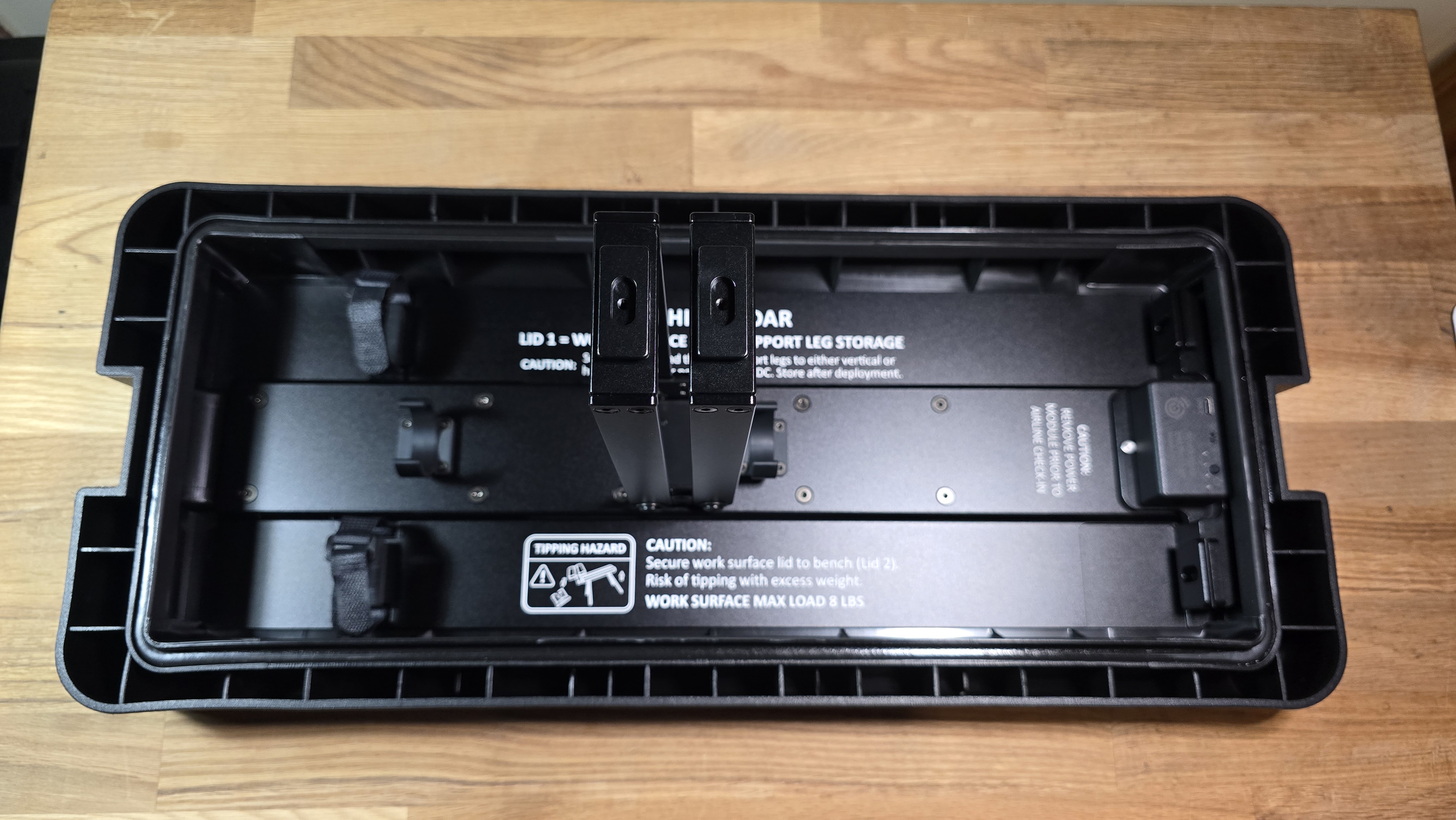 Articulating arms rotated outward on work surface lid